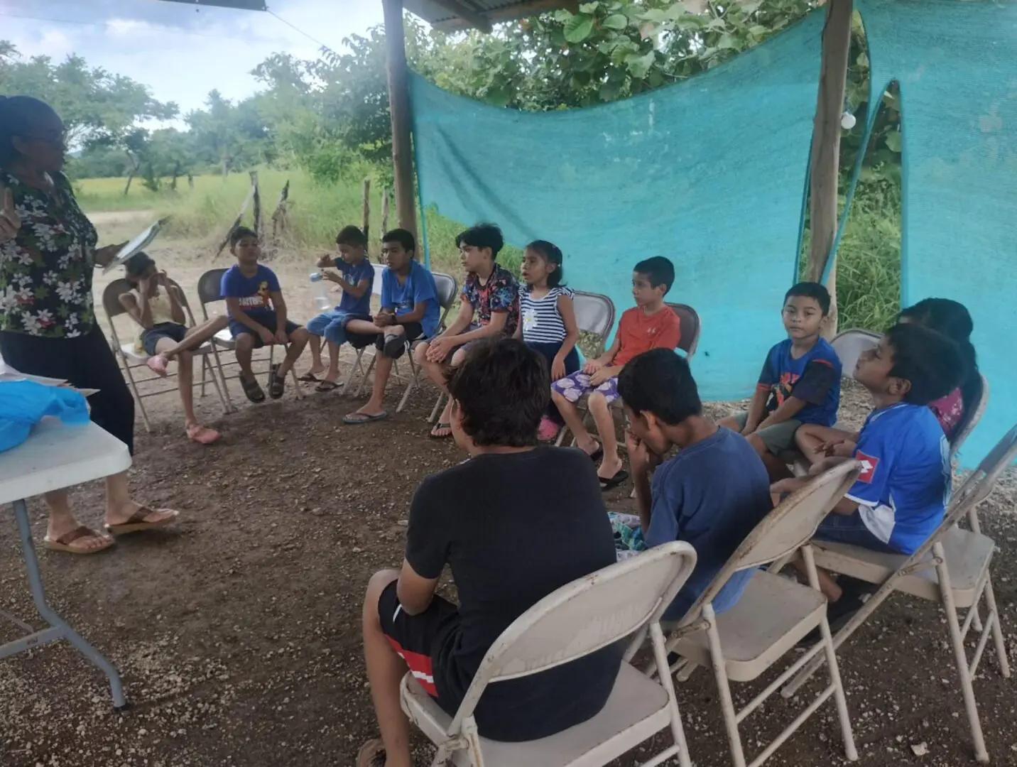 A group of people sitting in chairs under a tent.