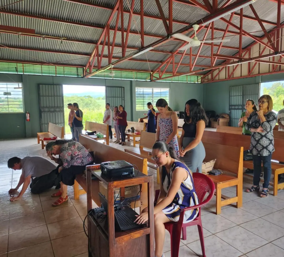 A group of people standing around in an open room.