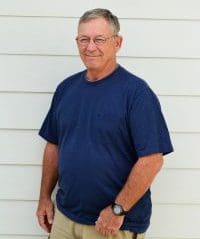 A man standing in front of a white wall.