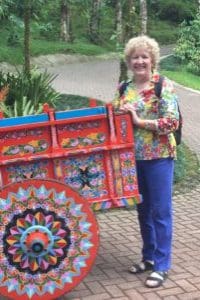 A woman standing next to a colorful cart.