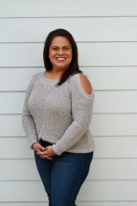 A woman standing in front of a white wall.