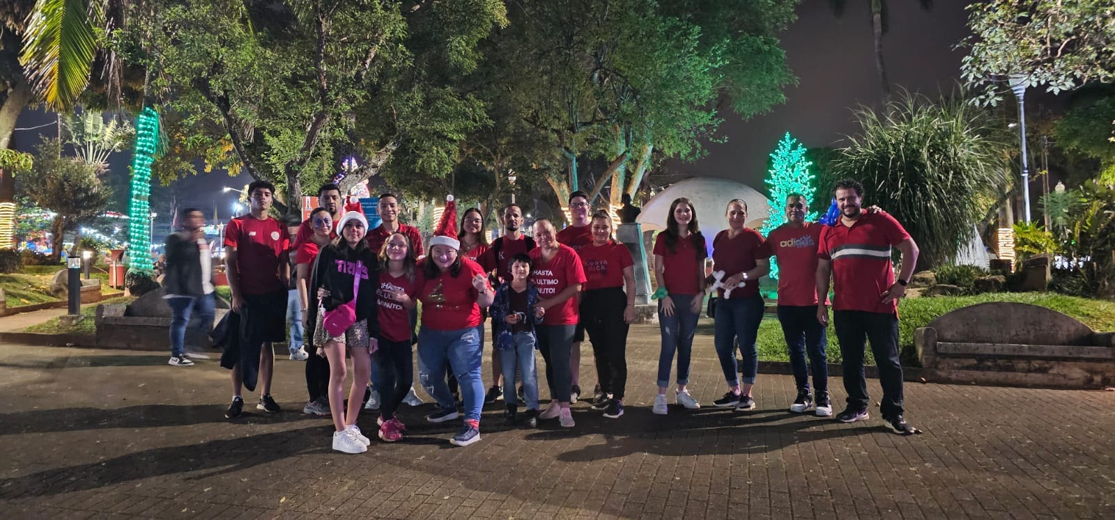 A group of people standing in the street at night.